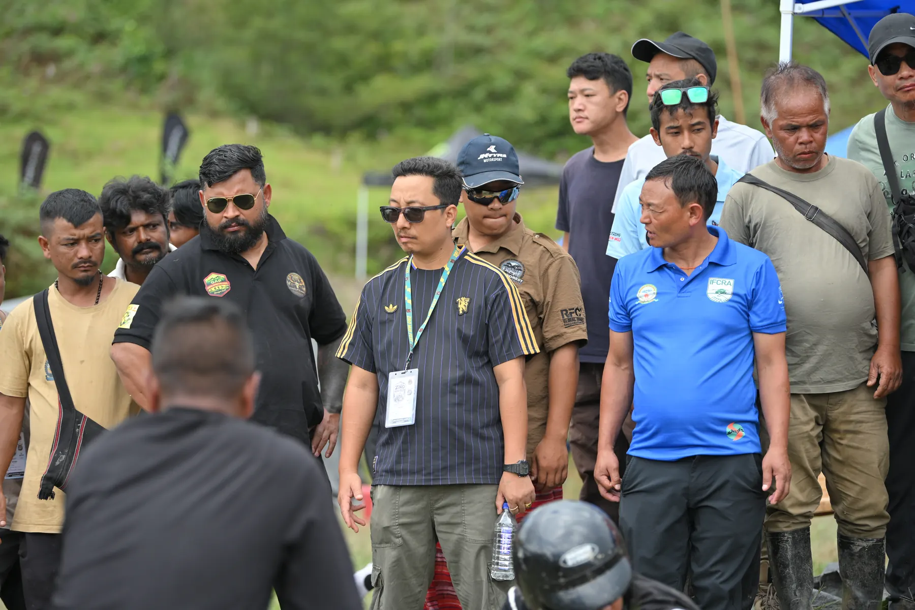 A group of officials and participants standing together on the field.